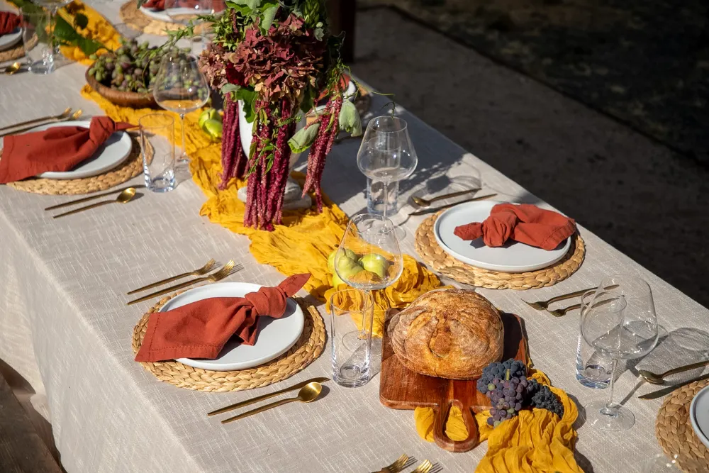 Rust napkins and a mustard gauze runner on linen.