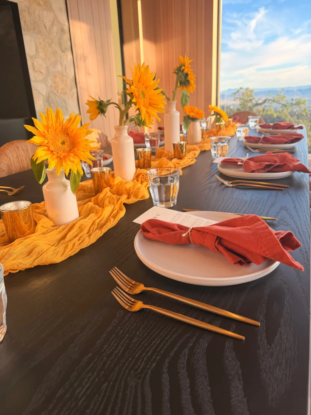 Sunflowers, mustard gauze and rust napkins at golden hour.